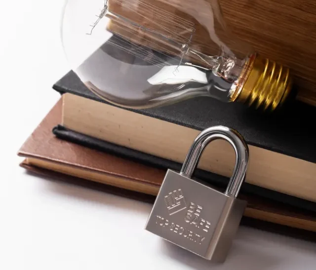 Une ampoule est posée sur une pile de livres anciens, un cadenas est placé devant. la confidentialité est assurée déontologie